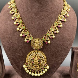 South Indian temple jewelry set featuring Lakshmi pendant and gold jhumkas with pearls
