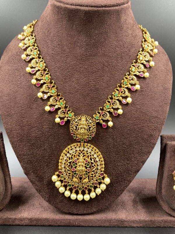 South Indian temple jewelry set featuring Lakshmi pendant and gold jhumkas with pearls