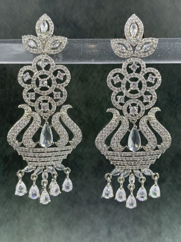 Ornate white chandelier earrings with floral design and teardrop stones