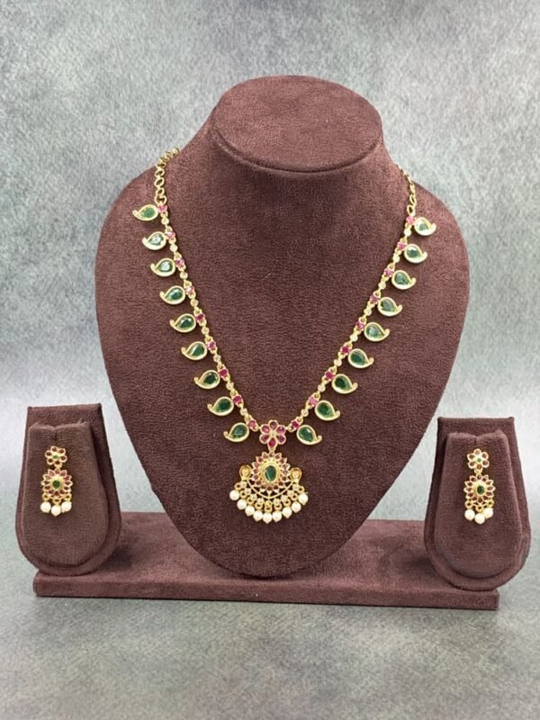 Traditional necklace with green stones, floral pendant, and pearl drops