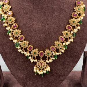 Designer necklace featuring floral and rectangular motifs with green and pink stones