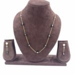 Gold-toned slim chain necklace with black floral beads and matching earrings