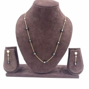 Gold-toned slim chain necklace with black floral beads and matching earrings