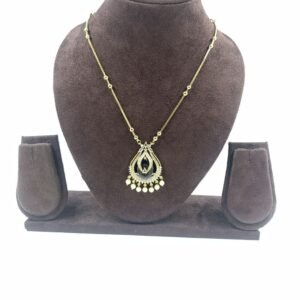 Gold-toned teardrop pendant necklace with black enamel detailing and gold bead accents