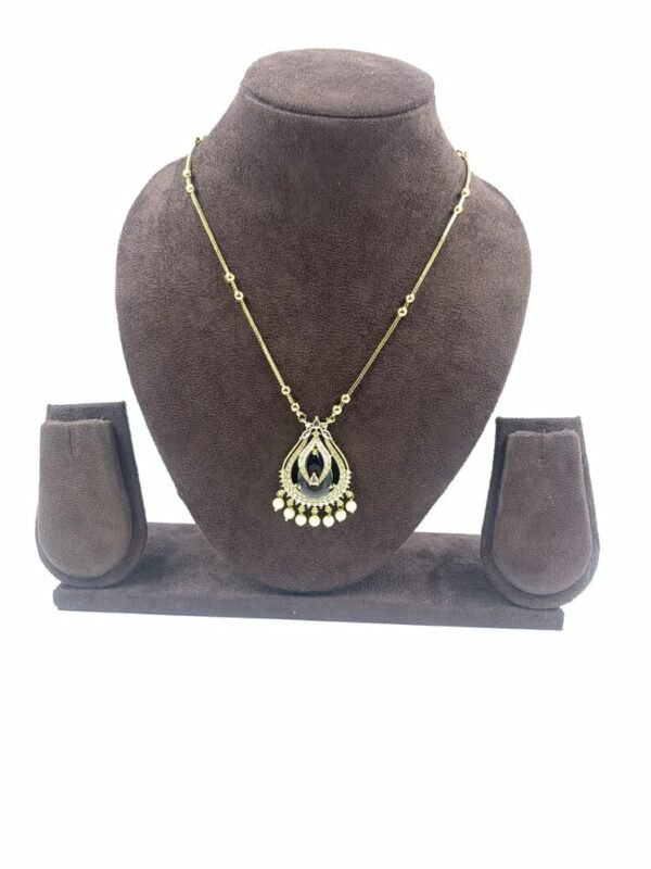 Gold-toned teardrop pendant necklace with black enamel detailing and gold bead accents