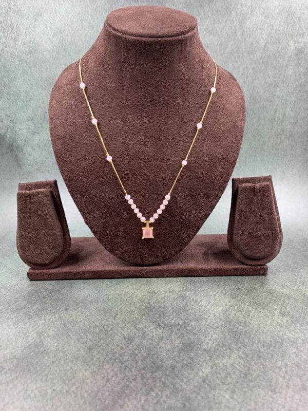 Invisible chain necklace featuring a pink rectangular stone and delicate white beads