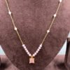 nvisible chain necklace featuring a pink rectangular stone and delicate white beads