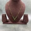 Invisible chain necklace featuring a green rectangular stone and delicate white beads