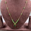 Invisible chain necklace featuring a green rectangular stone and delicate white beads